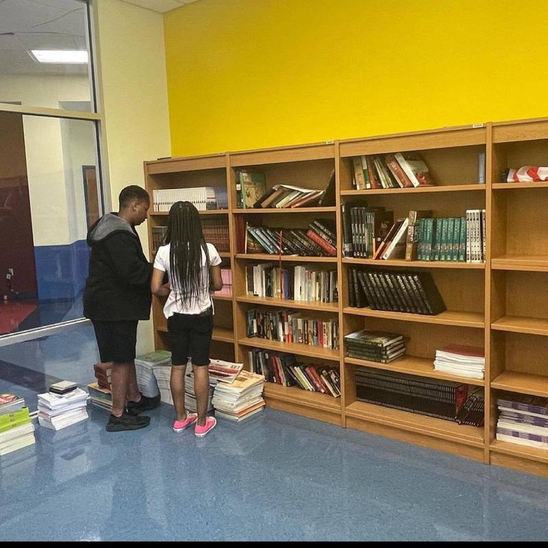 students placing books on shelves